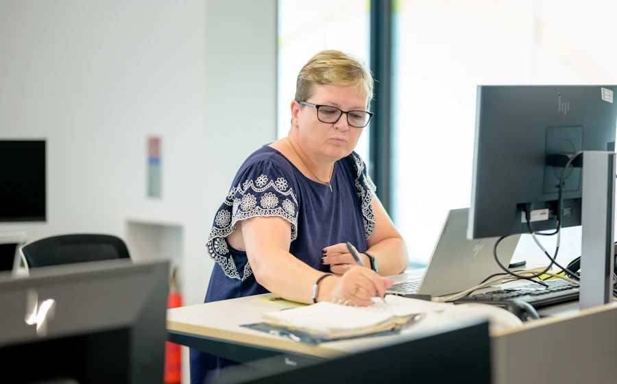 An office manager working through paperwork at her desk